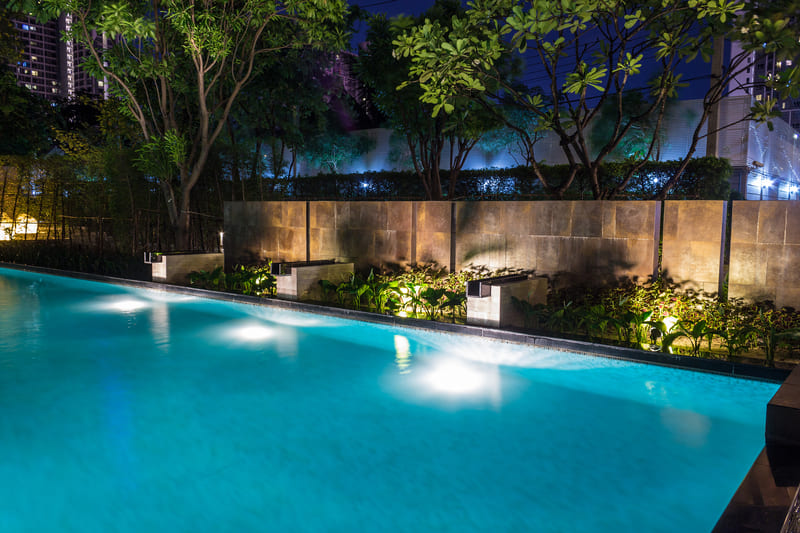 Área externa da piscina iluminada de noite