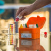 Mão pingando substância em recipiente com água para teste de pH da água