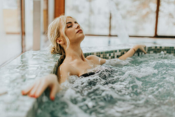 Mulher relaxando na piscina com hidromassagem